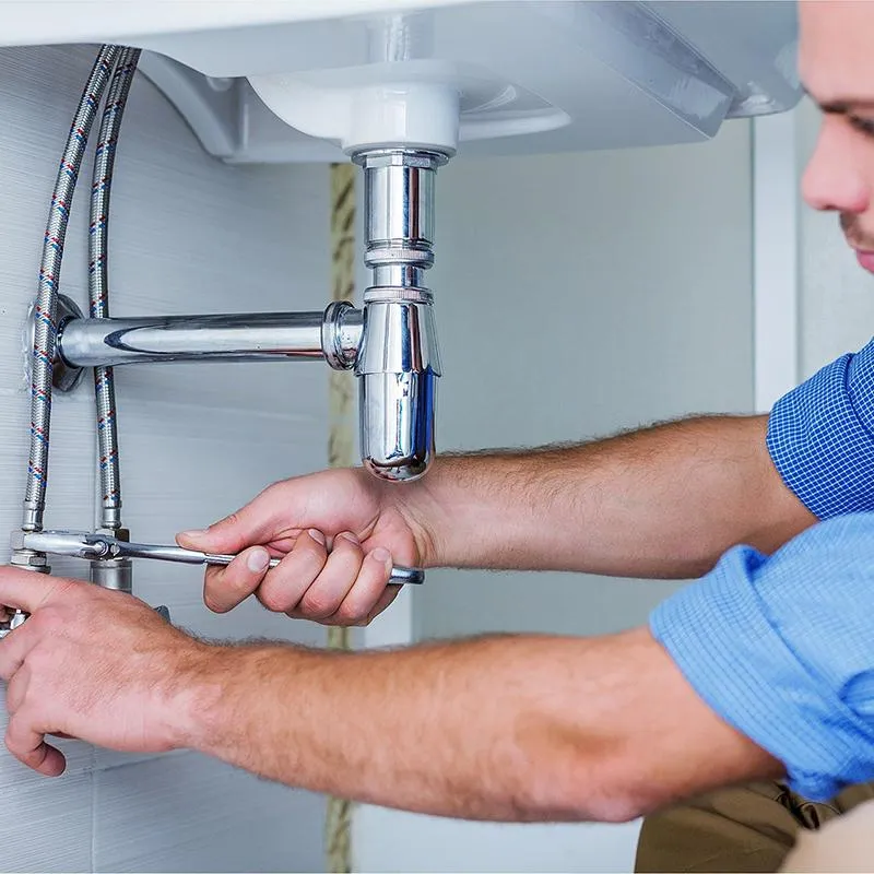 Plumber Fixing The Bathroom Sink